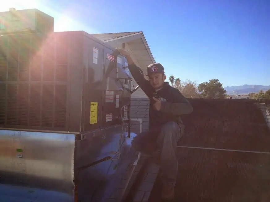 HVAC technician performing Heat Pump Repair on a rooftop unit in Los Gatos